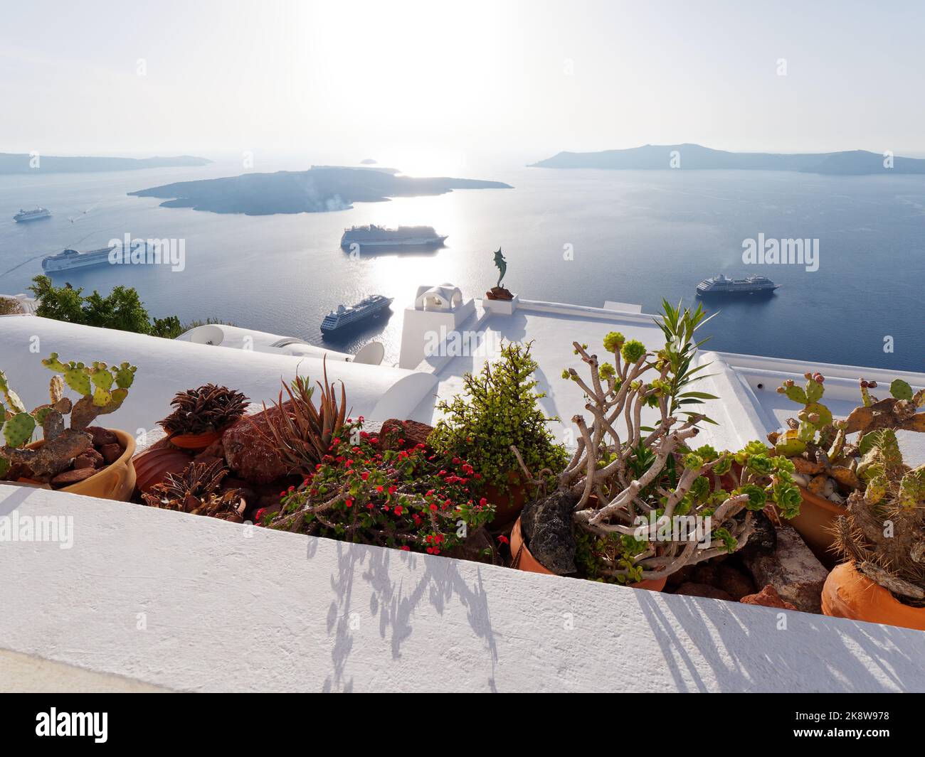 Vue sur Firostefani sur la caldeira à l'approche du coucher du soleil. Île grecque des Cyclades de Santorin dans la mer Égée. Cactus en premier plan Banque D'Images