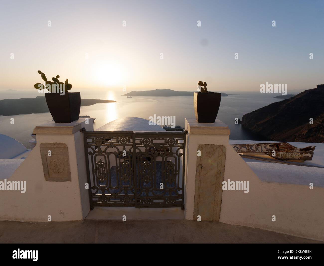 Vue sur la caldeira au coucher du soleil. Île grecque des Cyclades de Santorin dans la mer Égée. Pots de fleurs avec cactus en premier plan Banque D'Images