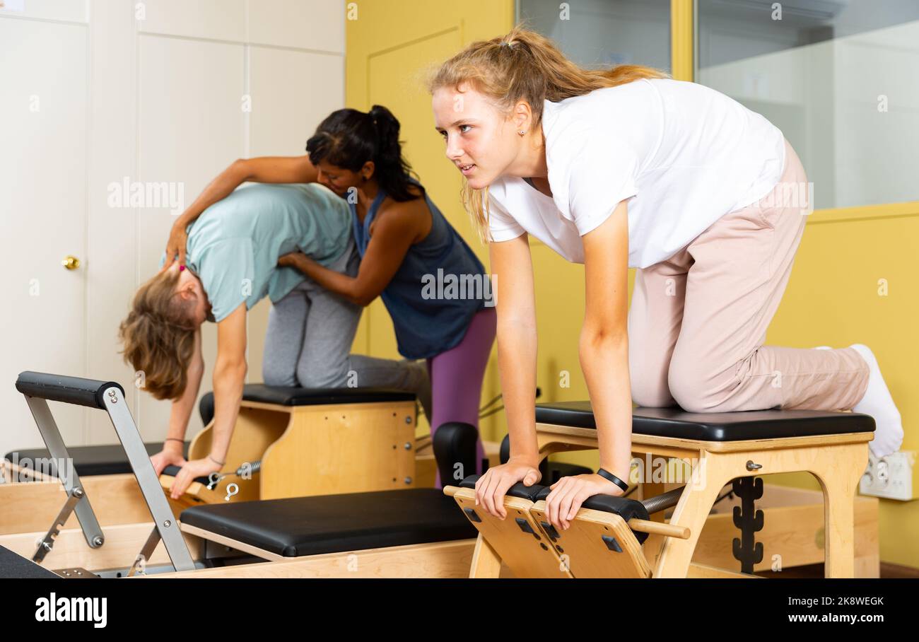 Adolescents d'entraînement pilates dans la salle de gym avec entraîneur Banque D'Images