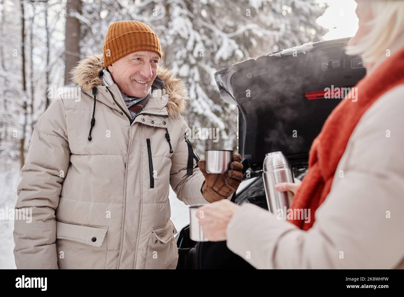 Portrait à la taille du couple heureux et mûr en dégustant une tasse de coco chaud en plein air pendant la randonnée d'hiver Banque D'Images