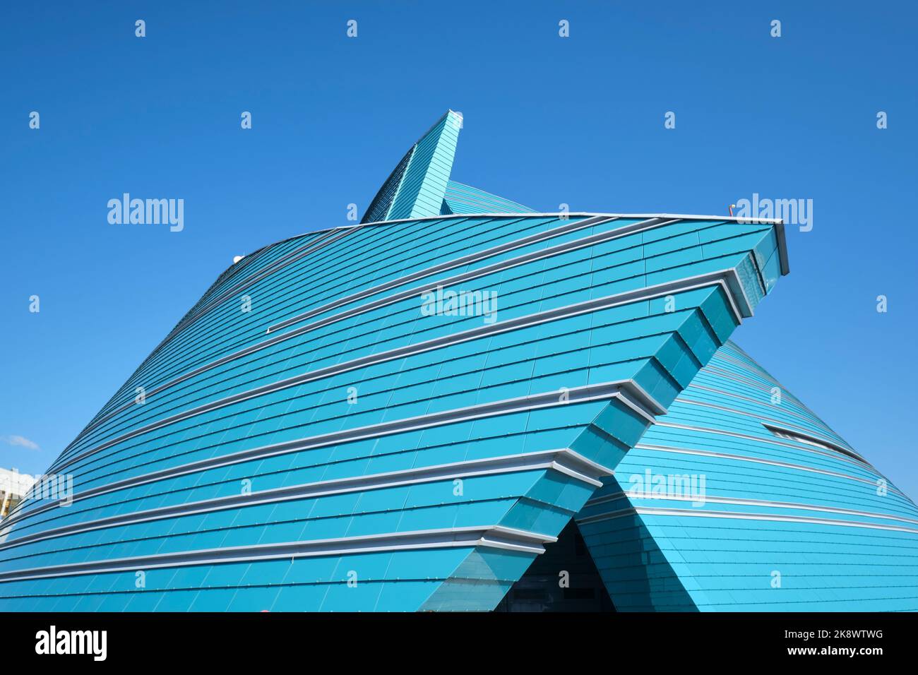 Vue sur la façade en verre bleu et vert en forme de fleur, moderne et incurvée. À la salle de concert du Kazakhstan à Astana, Nursultan, Kazakhstan. Banque D'Images