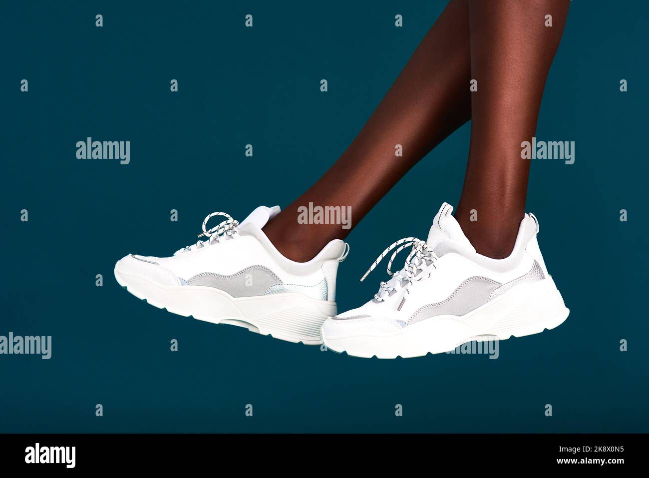 Essayez d'effectuer un entraînement avec mes chaussures. Une sportswoman méconnaissable portant ses baskets avant de vous entraîner sur un arrière-plan sombre dans le Banque D'Images