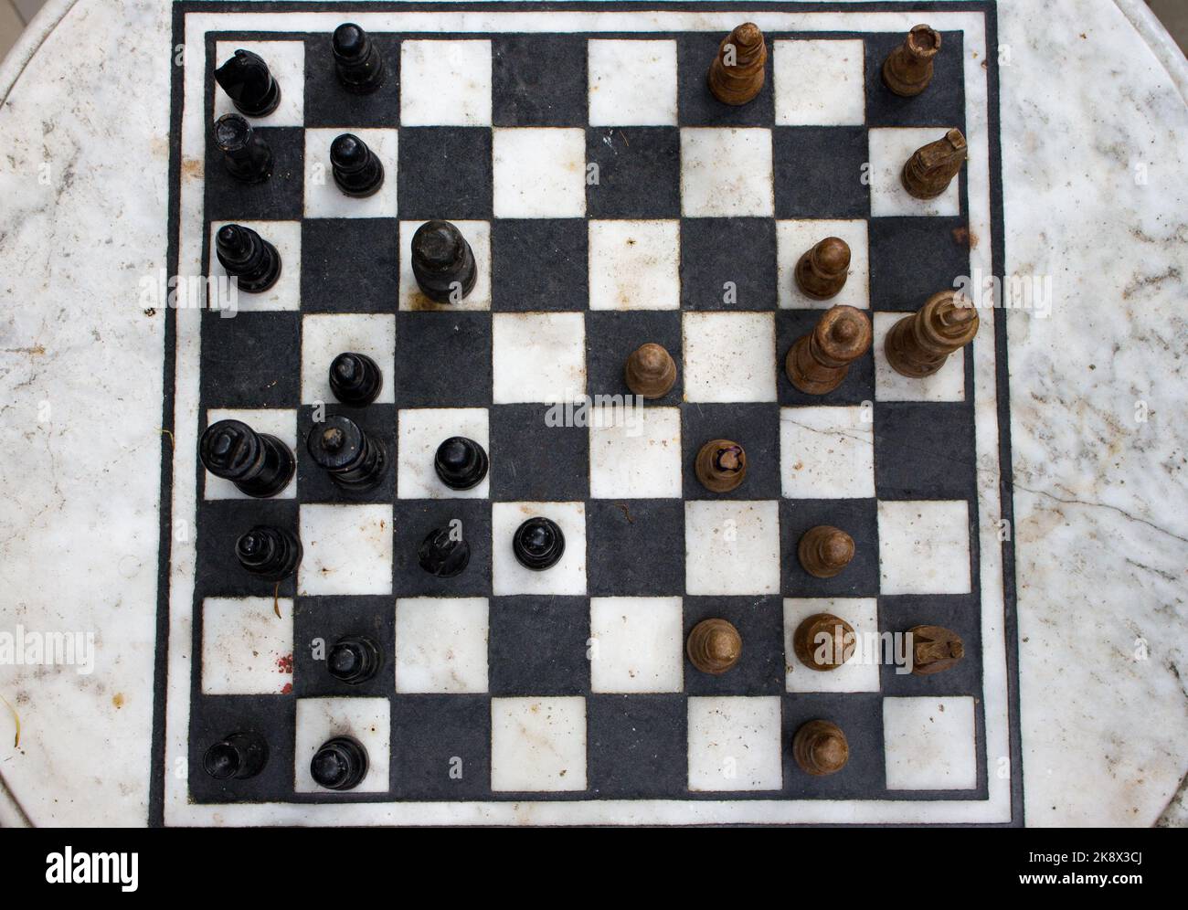 Échiquier extérieur en pierre avec vue sur les figures. Concept de concurrence et de stratégie. Concept de défaite et de combat. Pièces en bois d'échecs à bord. Jeu d'échecs. Banque D'Images