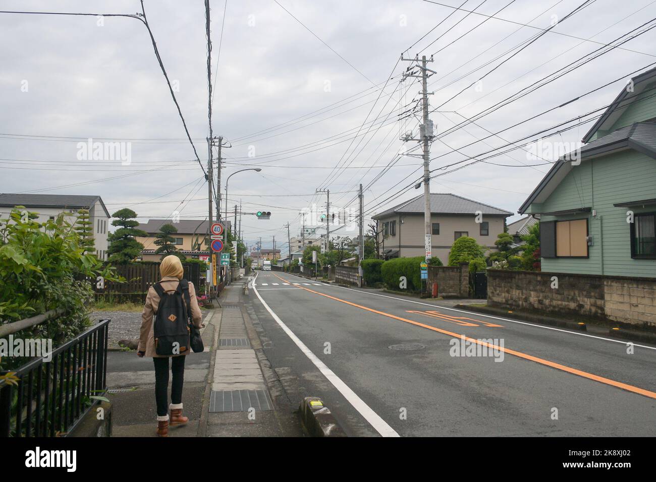 Vue sur la route principale vide dans la petite ville industrielle de Sudono avec maison et réseau électrique poste de câble et ciel bleu nuageux fond. Banque D'Images