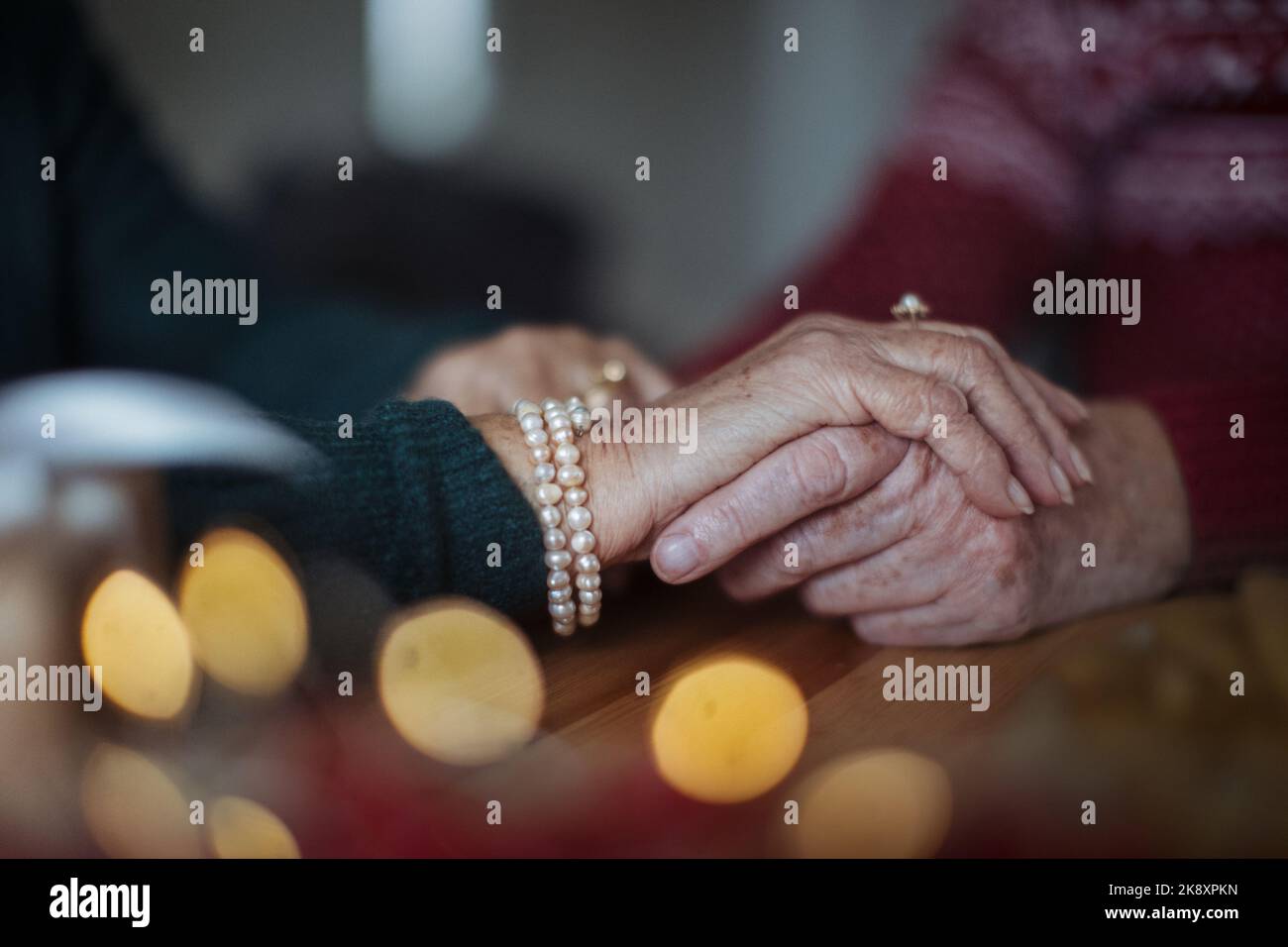 Gros plan des mains de couple de personnes âgées se tenant les unes les autres, pendant Noël. Banque D'Images