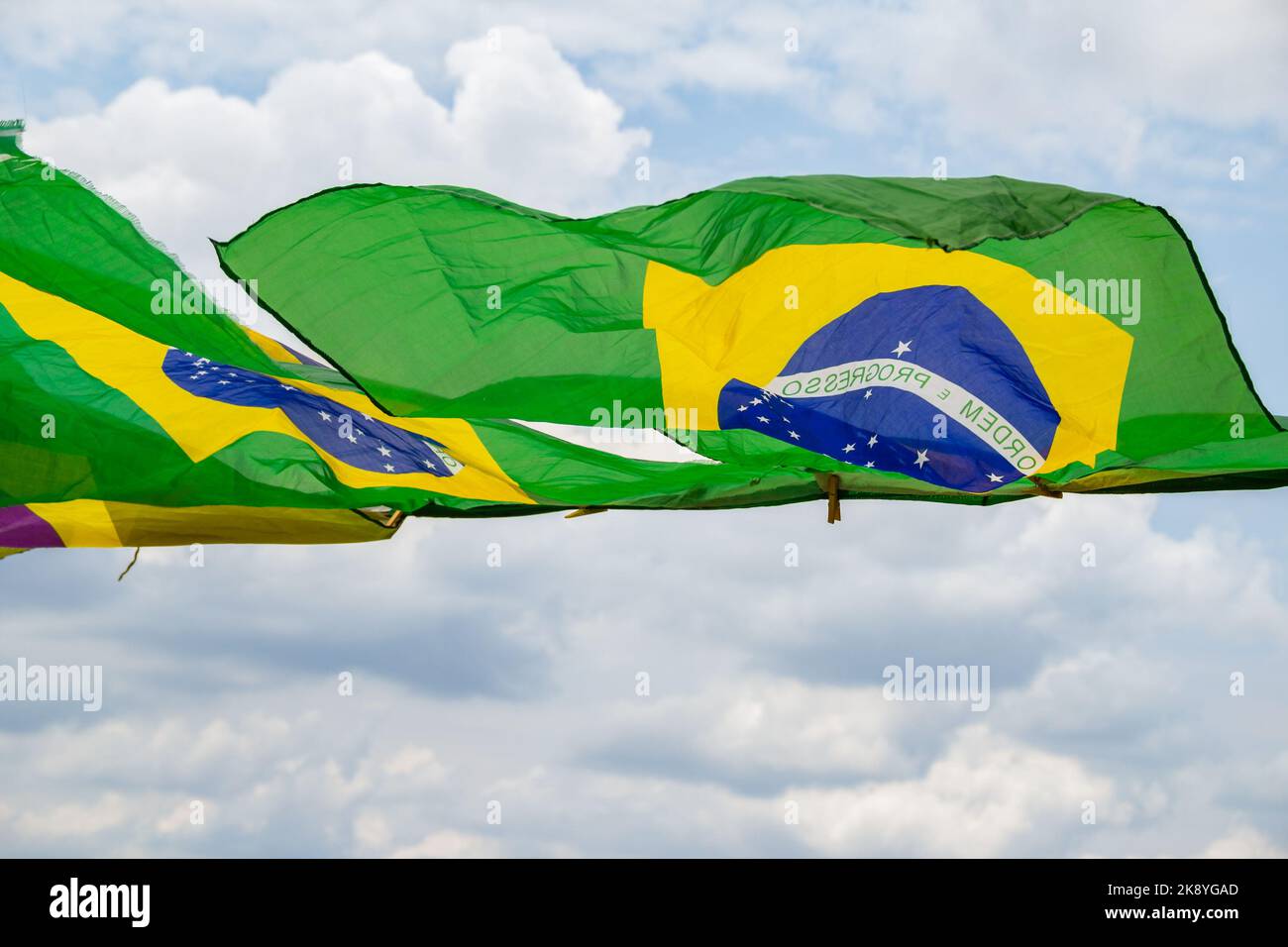 Aparecida de Goias, Brésil – 23 octobre 2022: Quelques drapeaux brésiliens, agitant dans le vent, sur la corde à linge avec le ciel nuageux. Banque D'Images