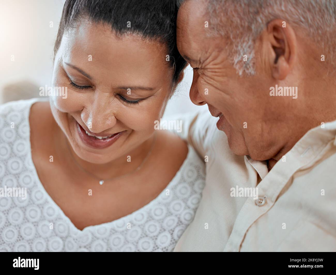 L'amour, la famille et le visage des couples âgés embrassent, se détendre et sourire tout en partageant et partageant un moment romantique dans leur maison. Senior, homme et femme Banque D'Images