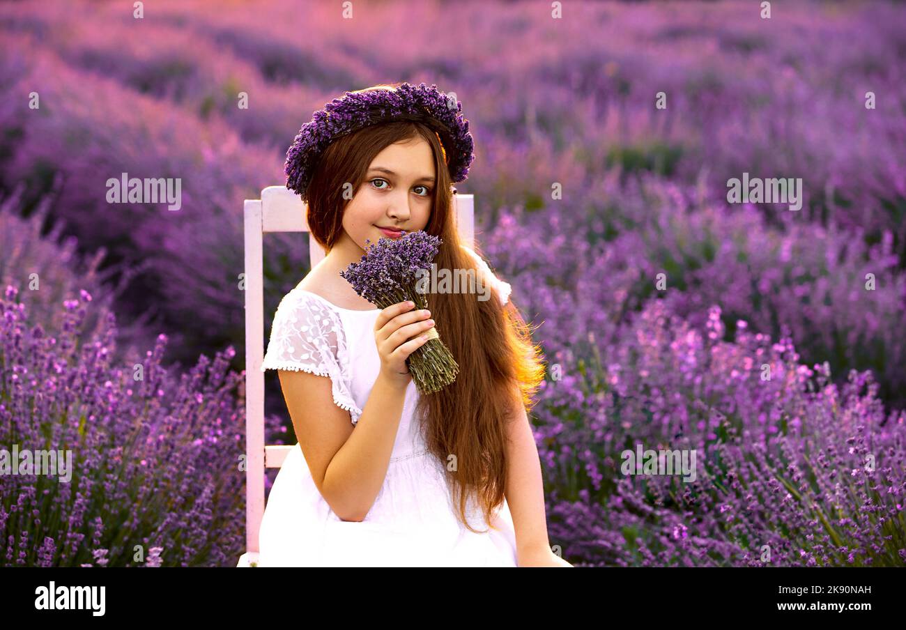 Une fille dans le champ de lavande au coucher du soleil avec un bouquet de lavande Banque D'Images