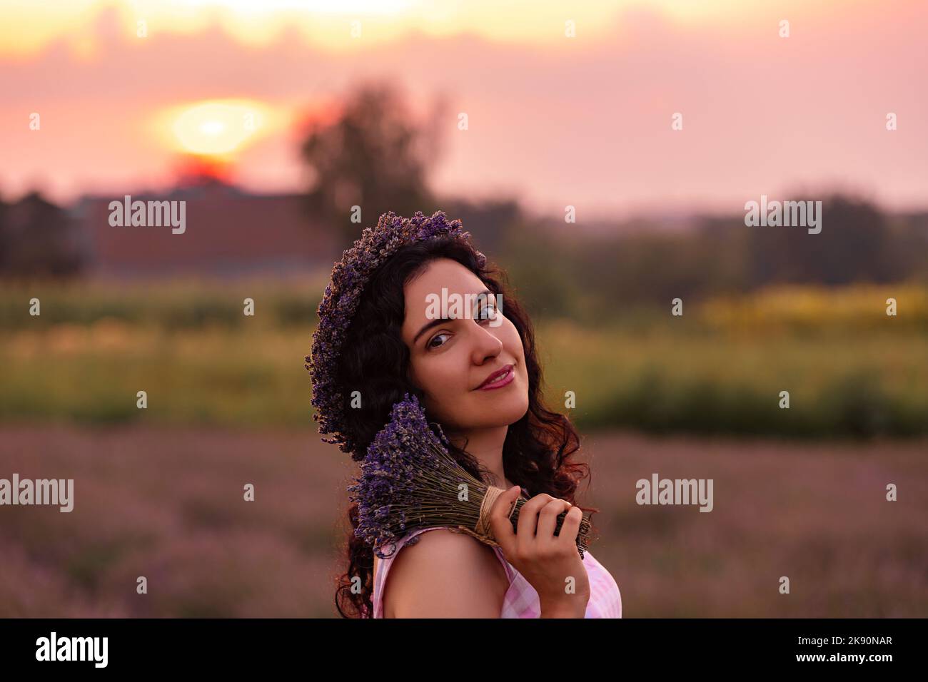 Une fille dans le champ de lavande au coucher du soleil avec un bouquet de lavande Banque D'Images