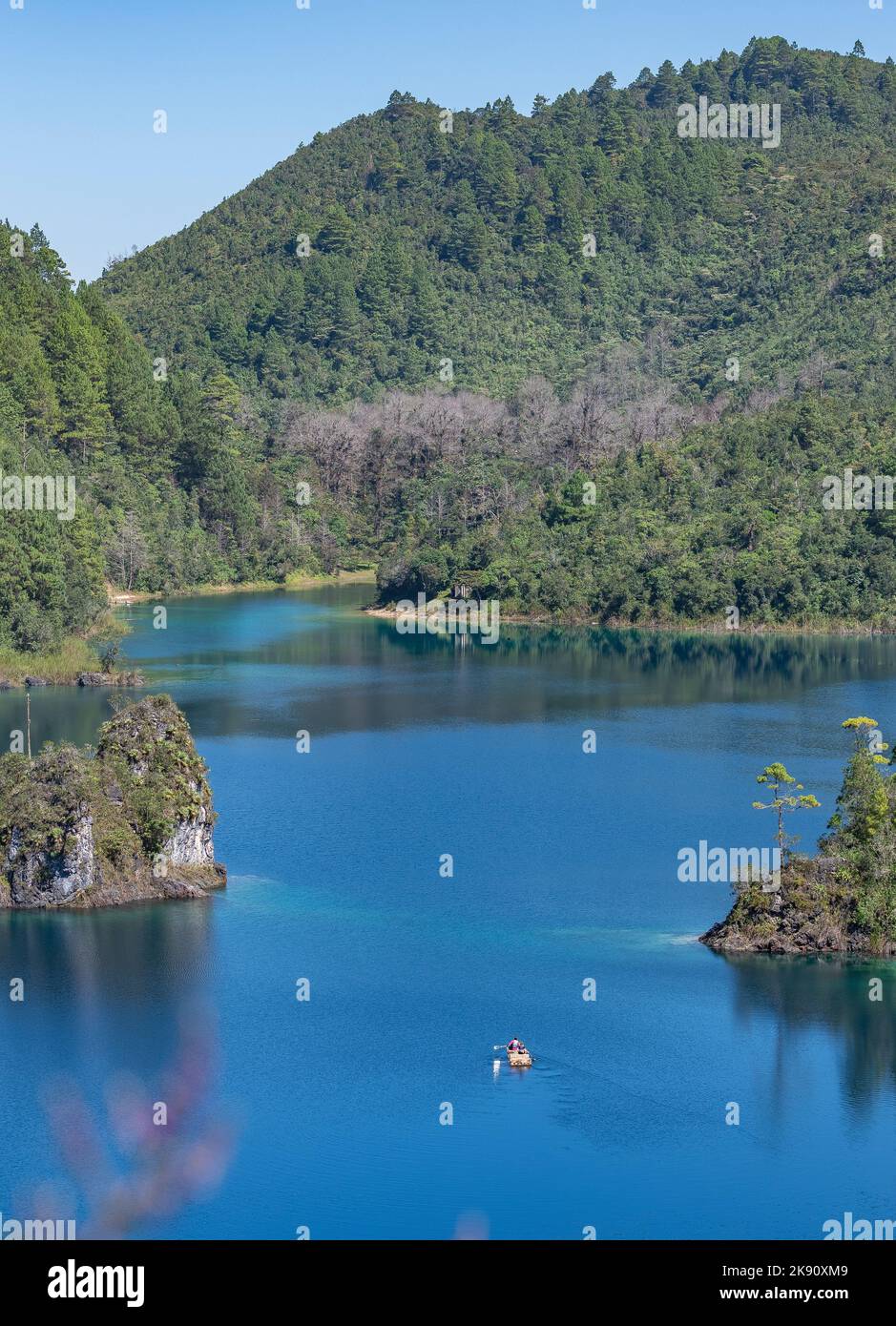 Plan vertical d'un bateau dans le lac Tziscao avec des montagnes couvertes de forêts de pins en arrière-plan, Mexica Banque D'Images