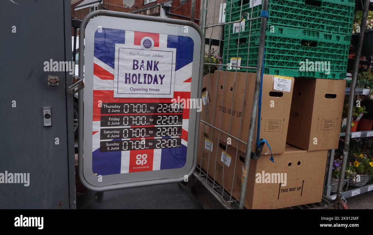 Queens Jubilé de platine, 2022. Signez les heures d'ouverture d'un magasin Co Op pendant ce jour férié spécial, avec un syndicat Jack. Cependant, le magasin ne ferme jamais du tout. Scène de rue banale. Banque D'Images