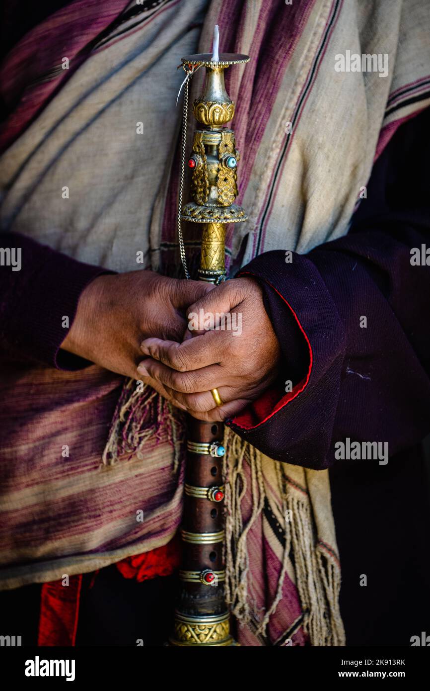 Une photo verticale des mains tenant une corne dorée antique rituelle au festival Tiji Banque D'Images