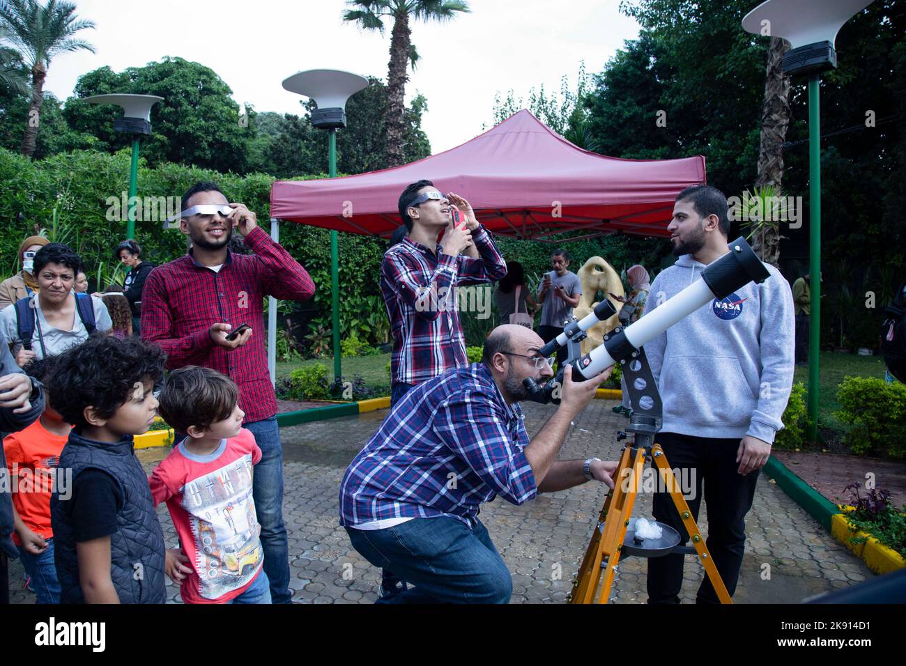 Le Caire, Égypte. 25th octobre 2022. Les gens utilisent des lunettes pour protéger leurs yeux pendant qu'ils montres l'éclipse solaire partielle lors d'un événement organisé par la Société égyptienne d'astronomie à la bibliothèque publique d'Heliopolis. Credit: Lobna Tarek/dpa/Alay Live News Banque D'Images