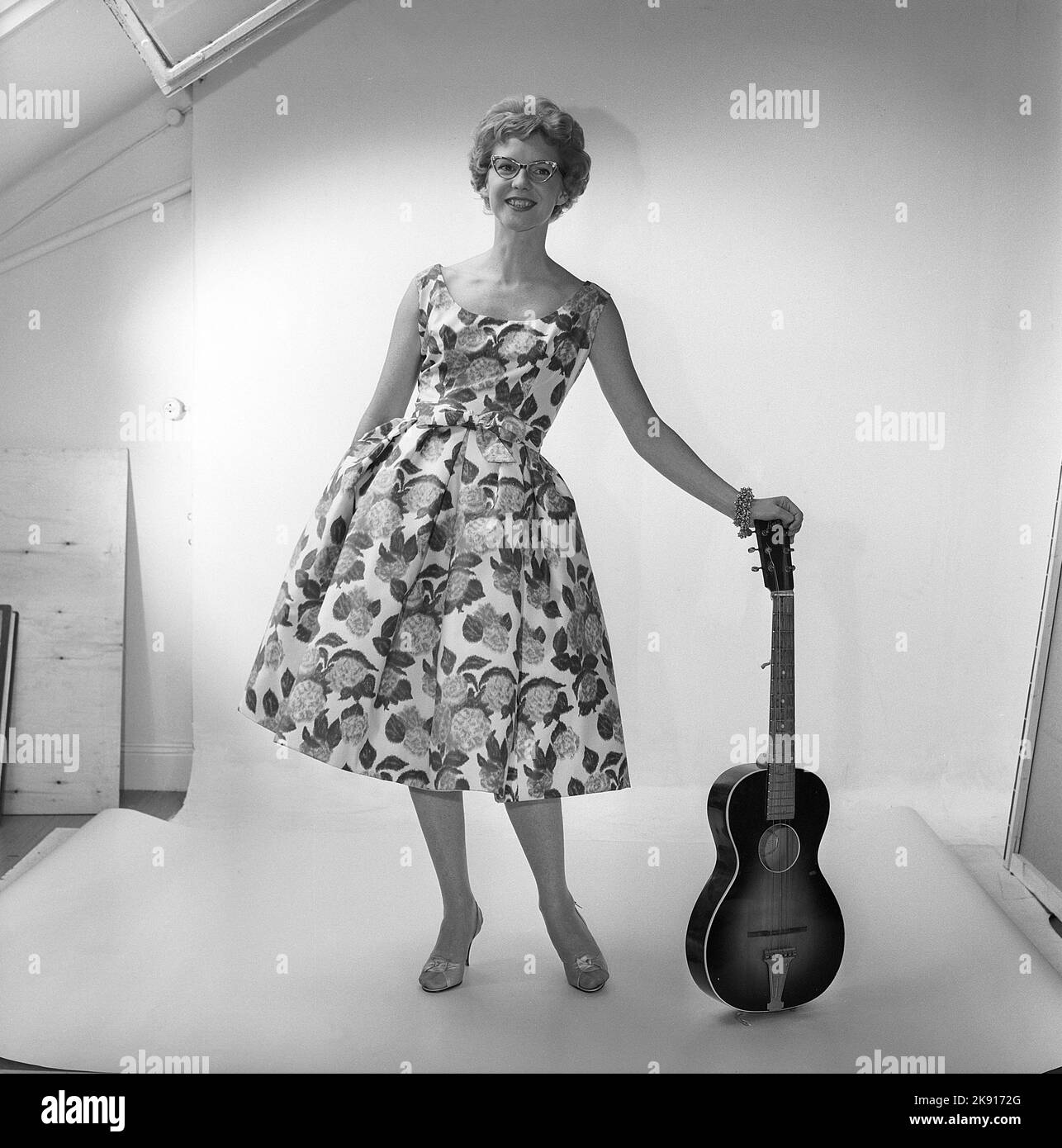 Dans le 1950s. Une femme dans le studio de photographes portant une robe à motifs de fleurs et de feuilles. Suède 1959 Kristoffersson réf. CF58-7 Banque D'Images