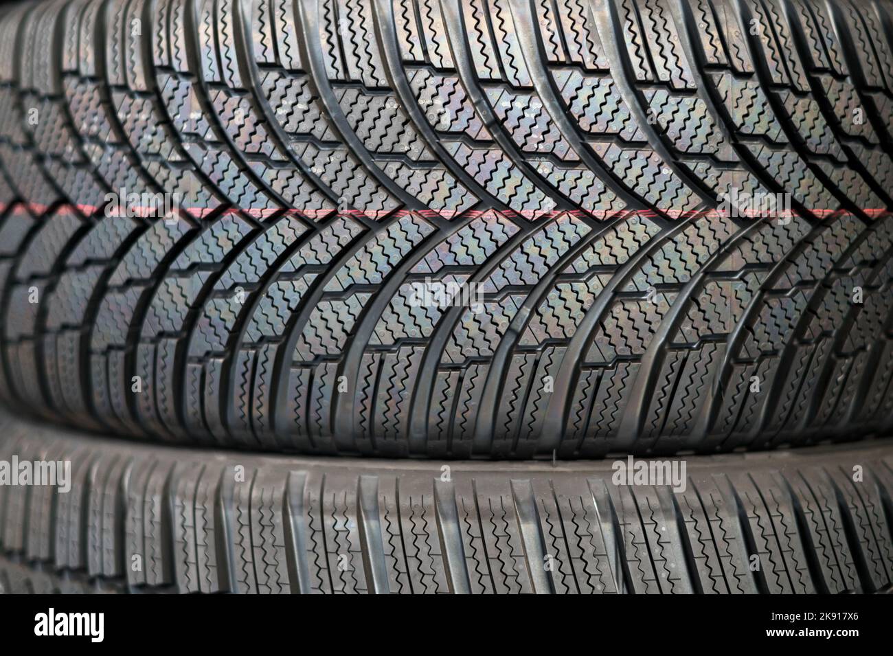Arrière-plan abstrait plein cadre de la texture des pneus d'hiver noirs avec un motif de bande de roulement simple empilés les uns sur les autres Banque D'Images