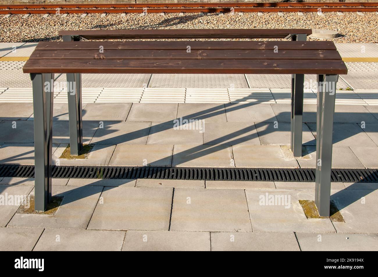 Banc incliné ou support incliné ou barre maigre (pas encore de nom établi) - nouveau remplacement moderne du banc traditionnel sur les gares de chemin de fer, bus ou tramway Banque D'Images