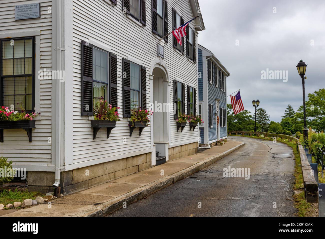 Plymouth, Massachusetts, Etats-Unis - 12 septembre 2022: Vue sur la rue des maisons le long d'une rue étroite sous ciel nuageux. Banque D'Images