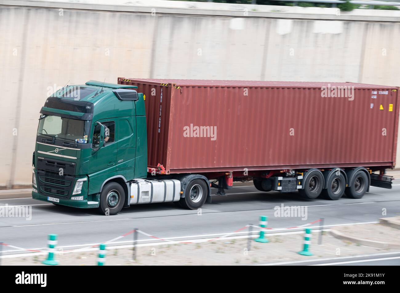 Camion Green Volvo FH chargeant une remorque à conteneurs rouge le long de Ronda Litoral à Barcelone Banque D'Images