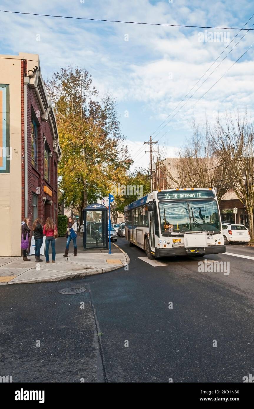 Quatre femmes se trouvent au coin de la rue devant la salle d'attente des autobus, devant Urban Outfitters dans le bâtiment Packard, sur la NW 23rd Avenue à Portland, Oregon. Banque D'Images