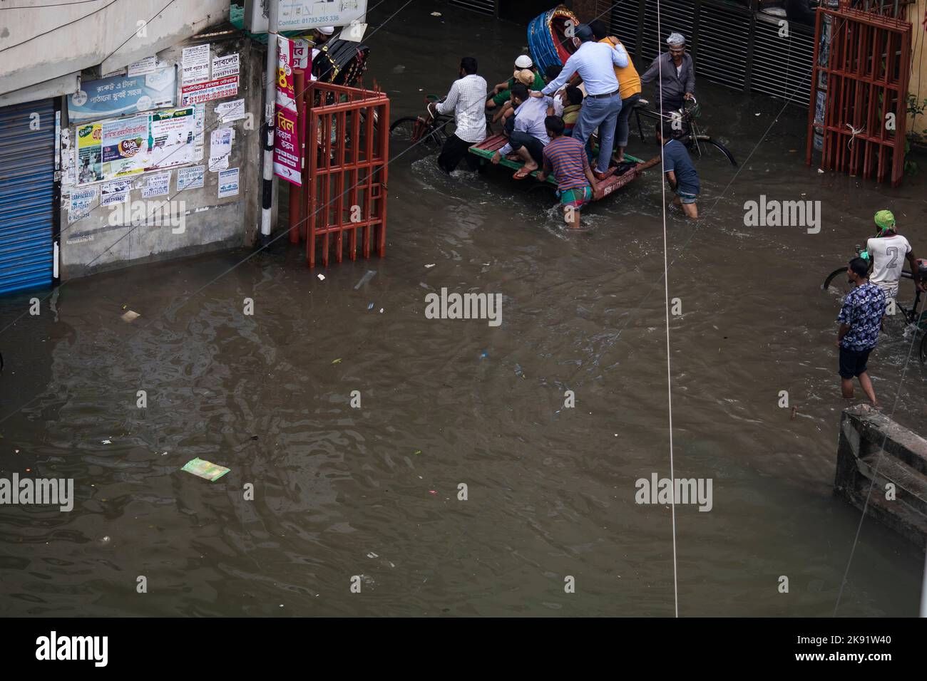 Dhaka, Bangladesh. 25th octobre 2022. Les propriétaires de pousse-pousse ont du mal à traverser une rue engortée à la suite de fortes pluies qui causent beaucoup de souffrances aux piétons et aux navetteurs. Le cyclone Sitrang frappe le Bangladesh en train d'établir des liaisons de communication et d'alimentation, inondant les rues pour faire encore des activités. (Image de crédit : © Sazzad Hossain/SOPA Images via ZUMA Press Wire) Banque D'Images