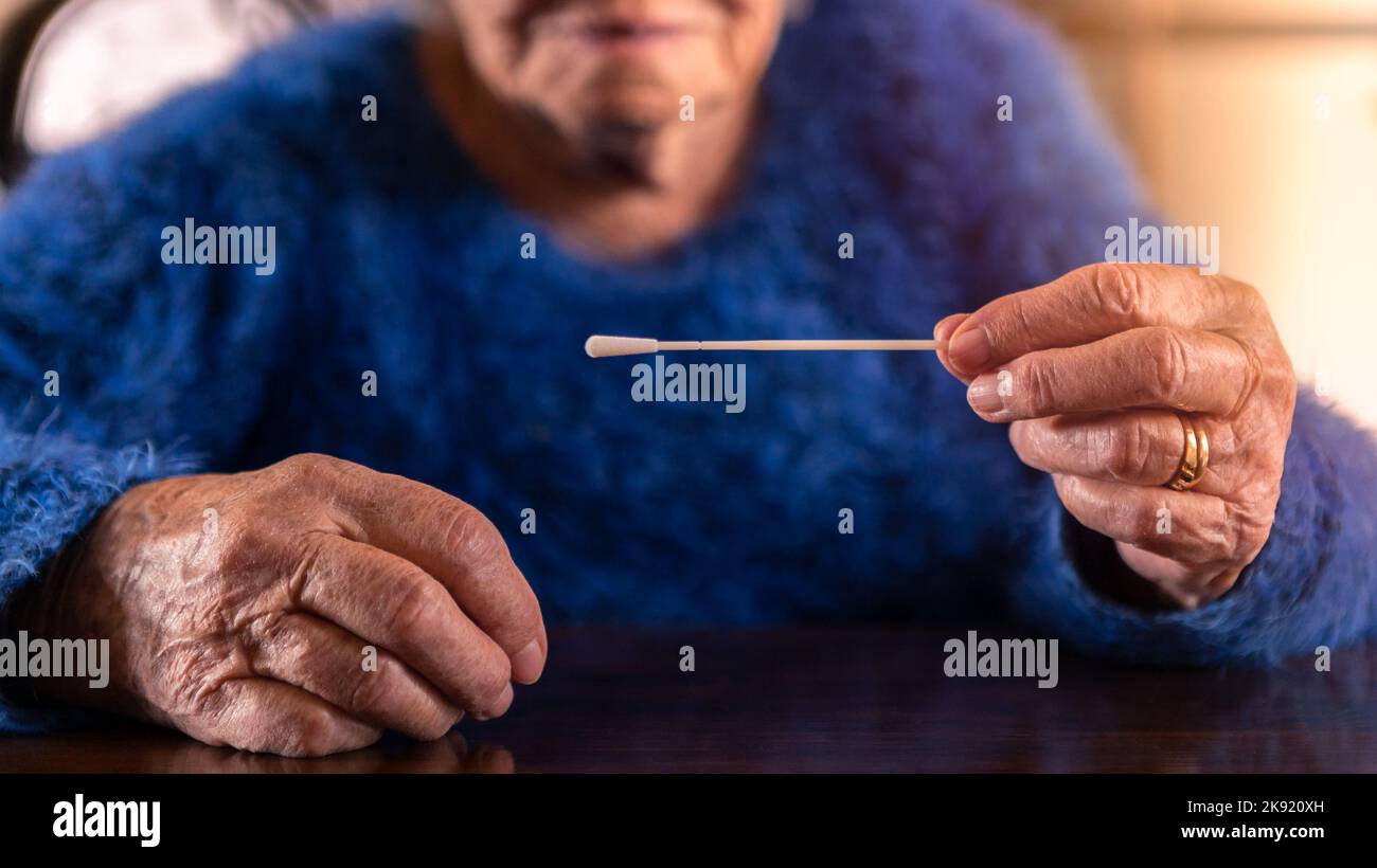 Gros plan de la femme âgée qui a effectué un auto-test à domicile pour Covid19 avec un kit d'antigène. Grand-mère caucasien introduisant un bâton nasal pour vérifier l'infection Banque D'Images