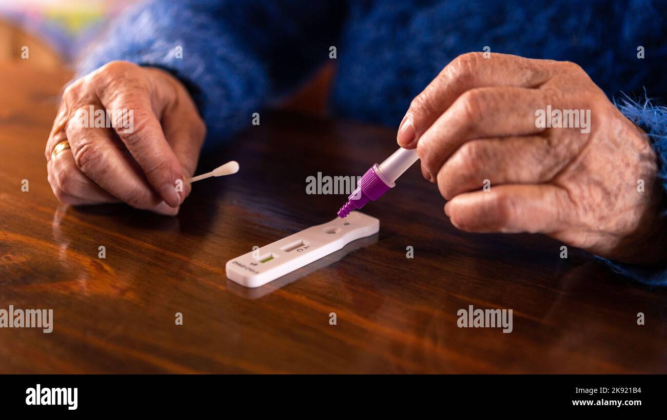 La vieille femme a placé l'échantillon dans le dispositif de test diagnostique de l'antigène covid-19 à la maison. Grand-mère caucasien utilisant un kit avec kit de cassette pour l'auto-test Banque D'Images