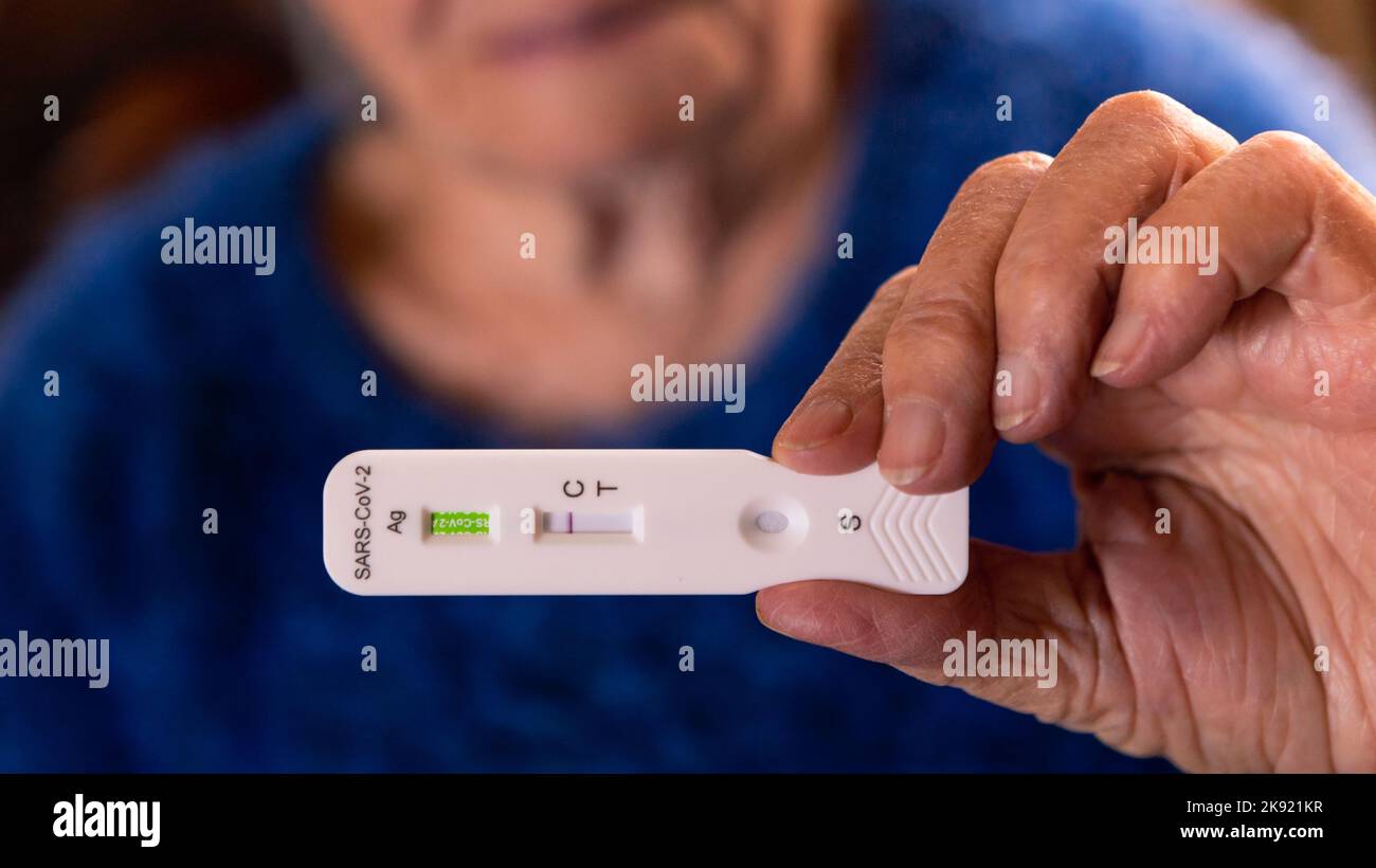 Le grand-mère caucasien fabrique un appareil de test rapide à domicile pour le virus Covid19 avec un résultat négatif. Grand-mère utilisant une cassette antigène de PCR express test f Banque D'Images
