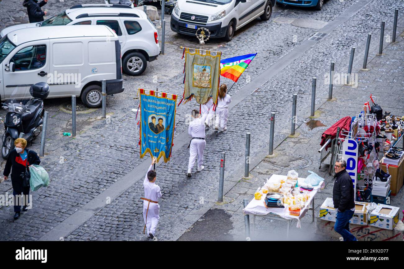 22 avril 2022-procession avec des personnes vêtues de blanc dans la rue de Naples portant de nombreuses bannières religieuses Banque D'Images