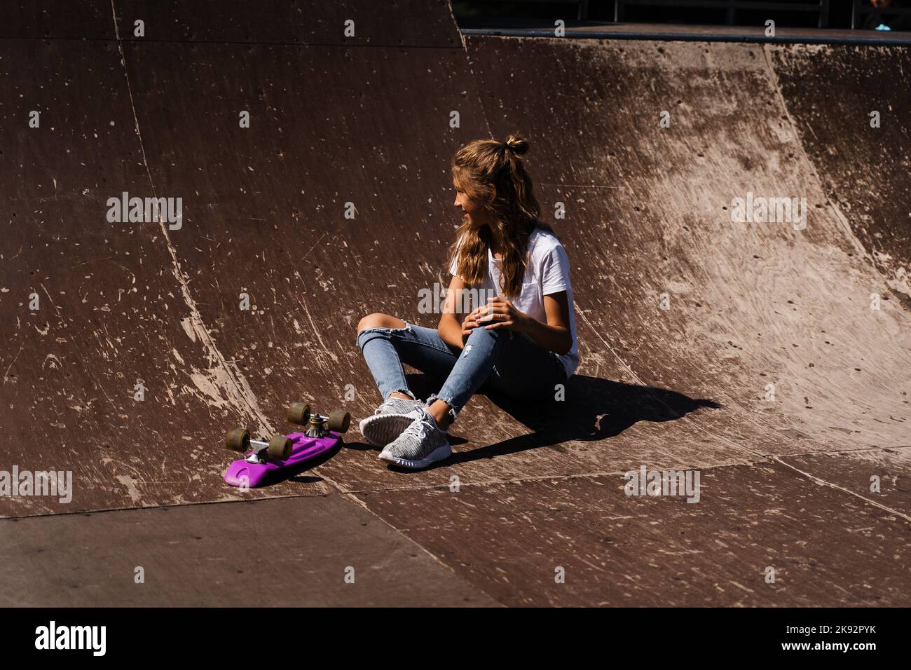 Enfant actif fille après la chute de penny board blessé, assis et sentir la  douleur sur la rampe de sport sur le terrain de jeu de skate Park Photo  Stock - Alamy
