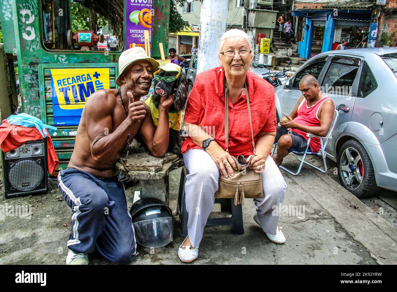 RIO DE JANEIRO - BRÉSIL, 31 JANVIER 2015 : une femme européenne senior a un repos dans un stand de nourriture local et pose avec le propriétaire et son chien à Rio de Janeiro, Banque D'Images