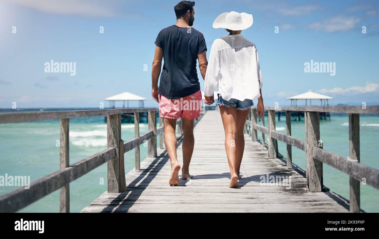 Quelle belle journée à explorer avec vous. Vue arrière d'un couple méconnaissable marchant sur une promenade et tenant les mains pendant les vacances. Banque D'Images