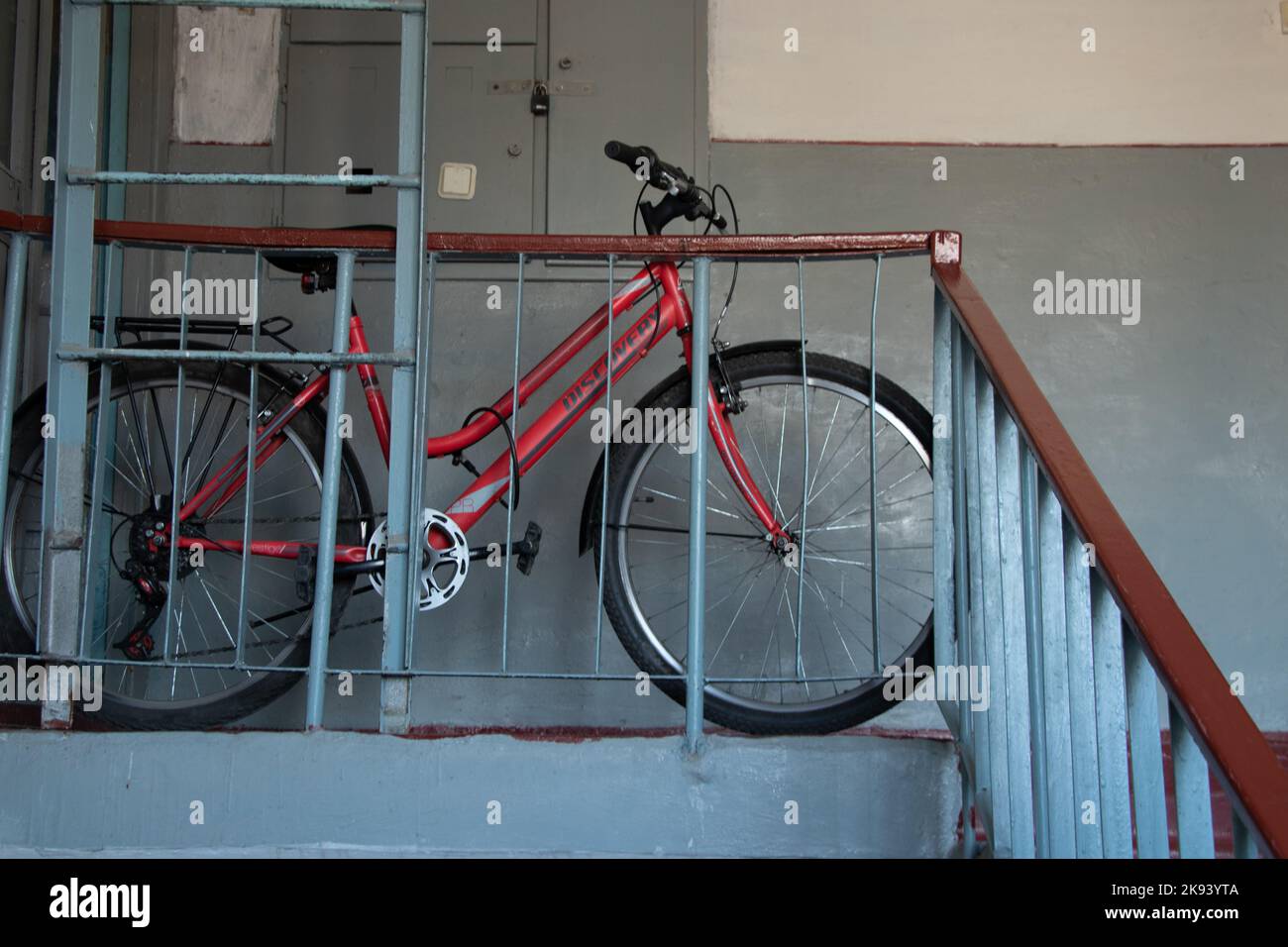 Ukraine Dnipro 10.04.2021 - le vélo est attaché à la rampe dans l'entrée résidentielle près de l'appartement, l'endroit pour ranger le vélo Banque D'Images