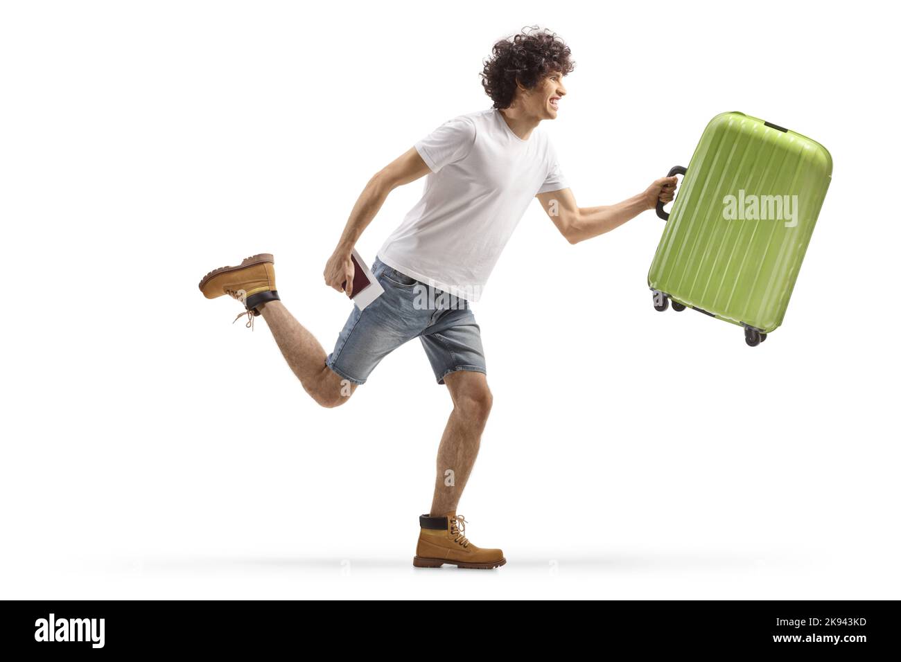 Photo pleine longueur d'un jeune homme décontracté qui court avec une valise isolée sur fond blanc Banque D'Images