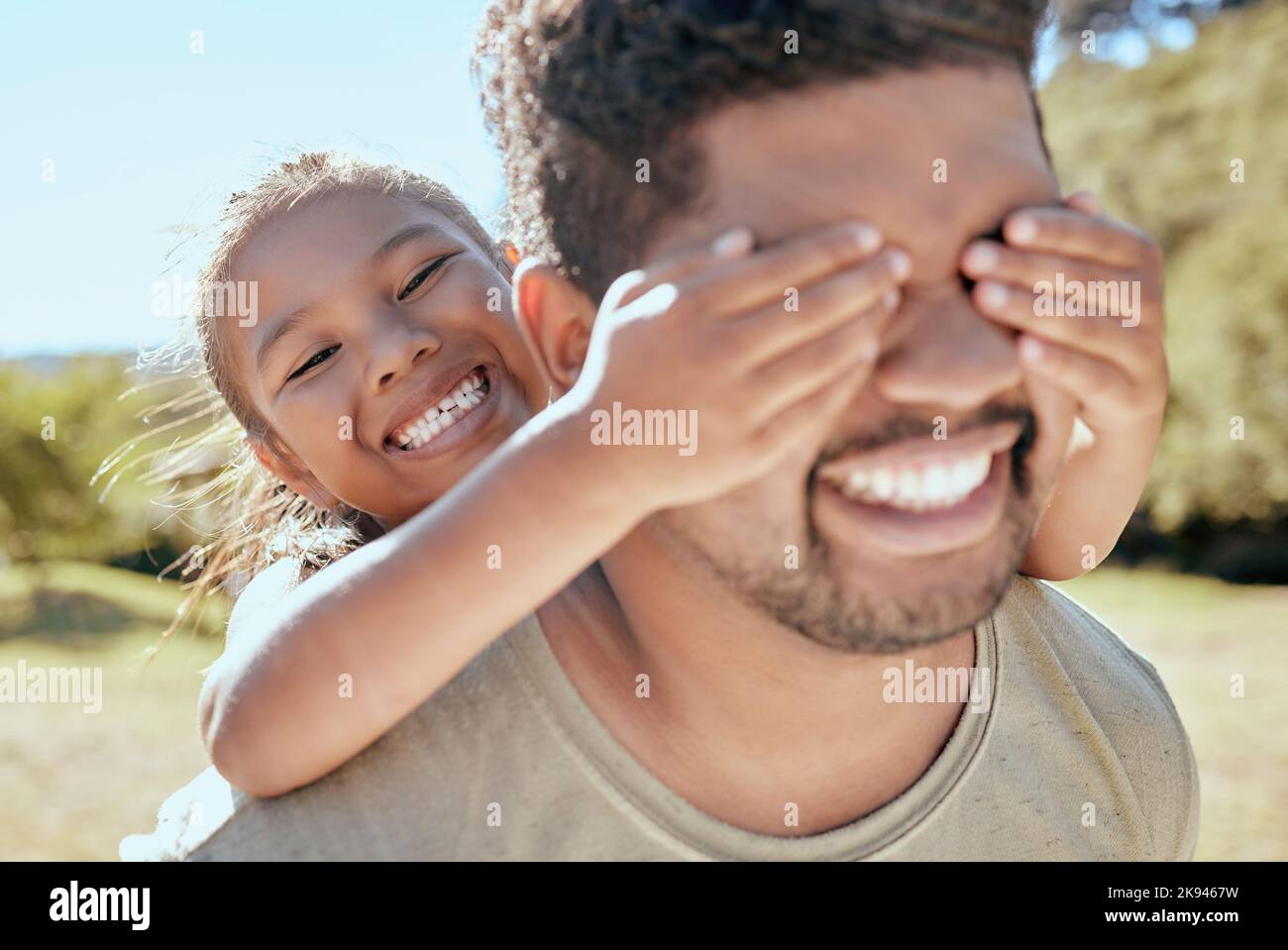 Jouer à cache et chercher, fille et père à l'extérieur avec l'amour et le soin de famille dans la nature. Papa heureux et jeune enfant ayant plaisir de qualité de temps dans un Banque D'Images