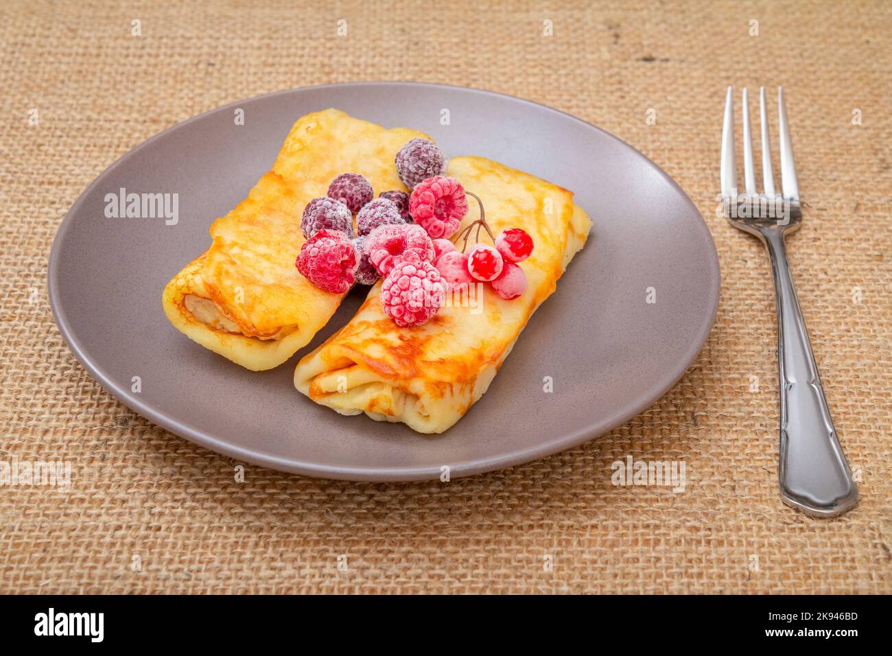 Crêpes faites maison et framboises surgelées sur l'assiette. Banque D'Images