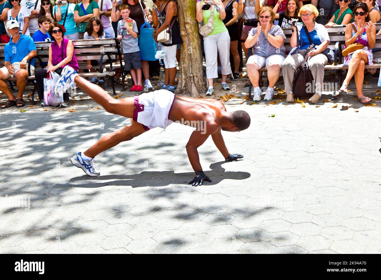 NEW YORK - 09 JUILLET : représentation de rue à Battery Park sur 09 juillet 2011 à New York. Les Noirs montrent la gymnastique et la breakdance et demandent Banque D'Images