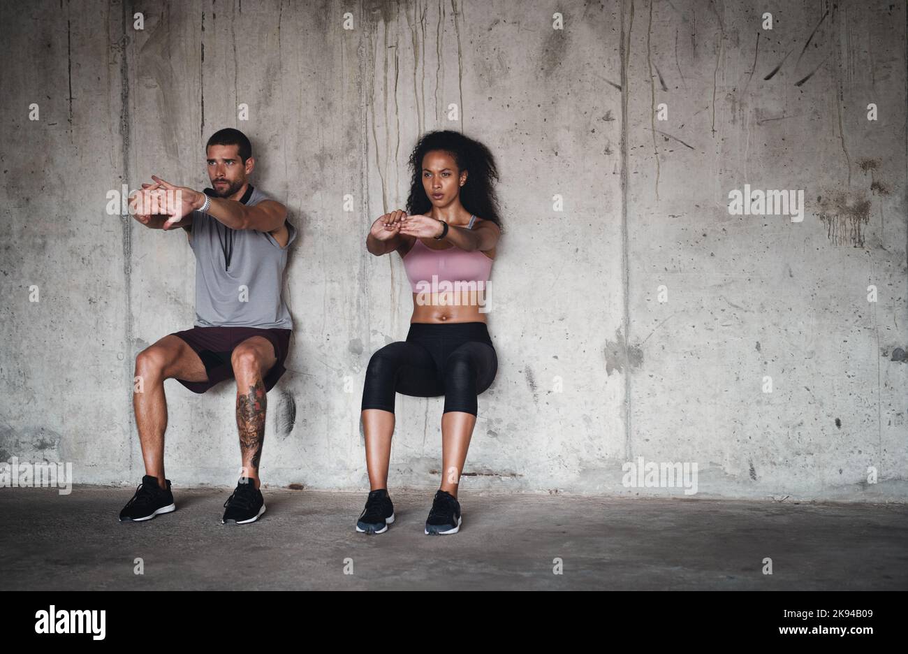 L'équilibre est la clé de tout dans la vie. Photo d'un jeune couple sportif qui s'exerce contre un mur à l'intérieur d'un parking souterrain. Banque D'Images