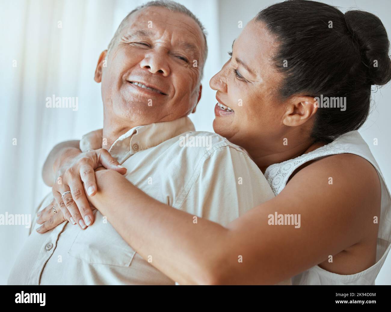Couple de retraite, amour et câlin dans la maison pour le romantisme, se détendre et sourire dans le salon Colombie ensemble. Homme âgé heureux, femme âgée ou pension Banque D'Images
