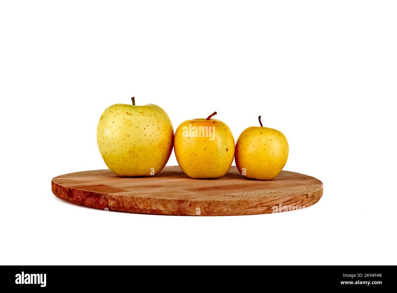 Pommes jaunes sur une planche à découper en bois. Ordre de taille des pommes jaunes. Arbre doré délicieux isolé du plus grand au plus petit Banque D'Images