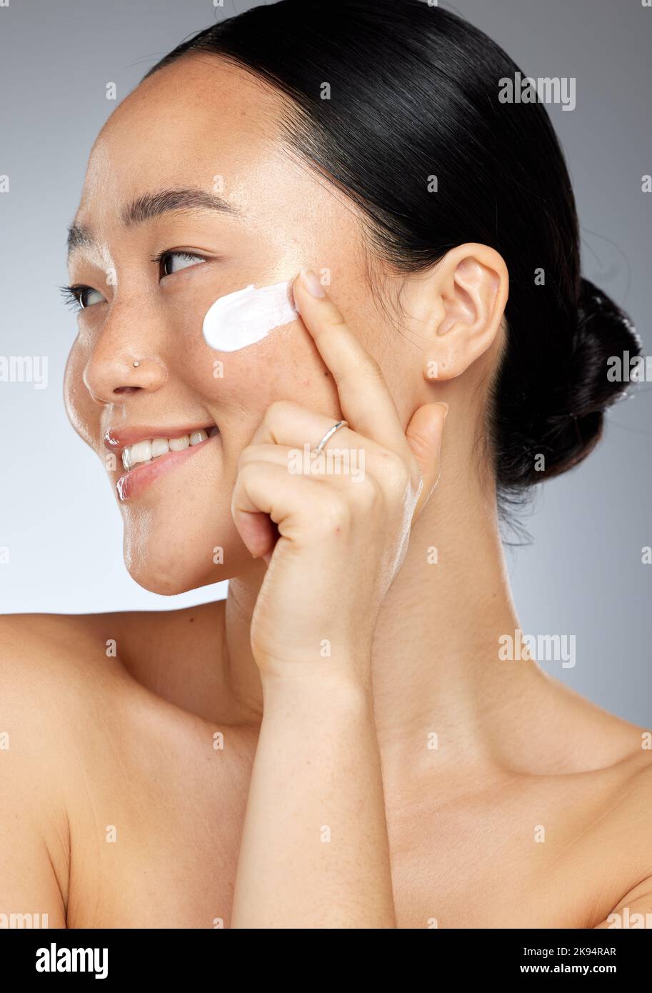 Crème de soin de peau coréenne, Happy et visage d'une femme avec un sourire en utilisant la lotion. Le bonheur d'une personne de Corée souriant sur le bien-être du visage Banque D'Images
