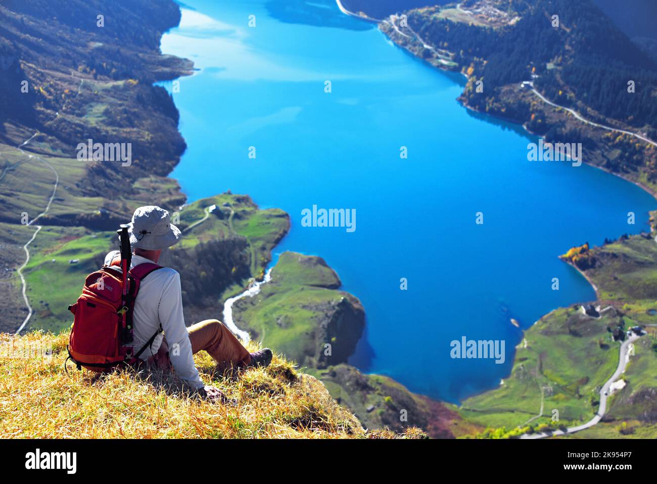 Randonneur de montagne assis sur une montagne et profitant de la vue sur le Lac de Roselend, France, Savoie, Beaufortain Banque D'Images