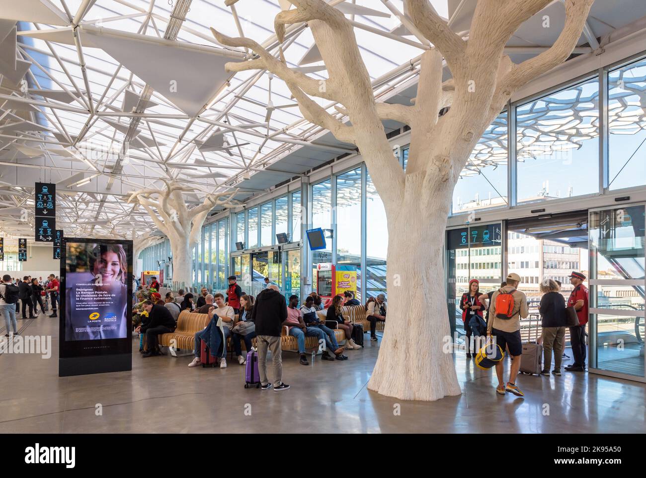 Les voyageurs attendent un train dans le hall de la mezzanine de la gare SNCF de Nantes, en France, conçu par Rudy Ricciotti et doté de piliers en forme d'arbre. Banque D'Images