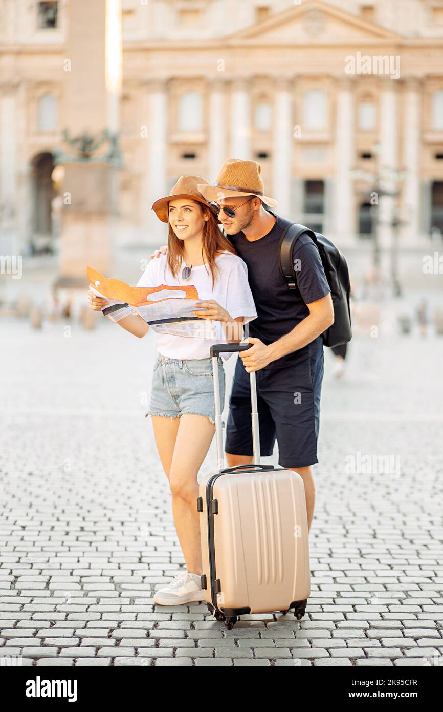 Les touristes heureux regardant une carte et de choisir un hôtel. Couple de touristes en vacances à Rome, Italie. Touristes satisfaits à la recherche d'une direction sur une carte Banque D'Images