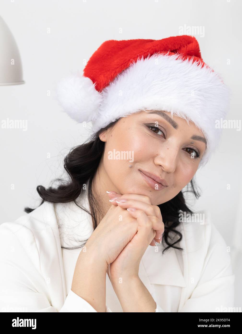 Une jeune femme réussie porte un chapeau de noël sur le bureau de beauté de fond. Portrait professionnel esthéticienne ou directeur et vacances d'hiver Banque D'Images
