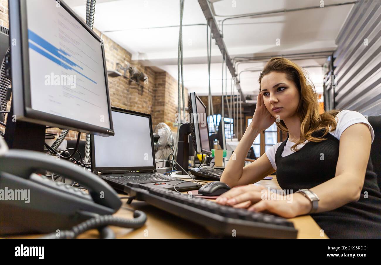 L'Agence des médias : programmeur informatique. Un professionnel de la création au travail sur son bureau. Texte HTML générique à l'écran. À partir d'une série d'images associées. Banque D'Images