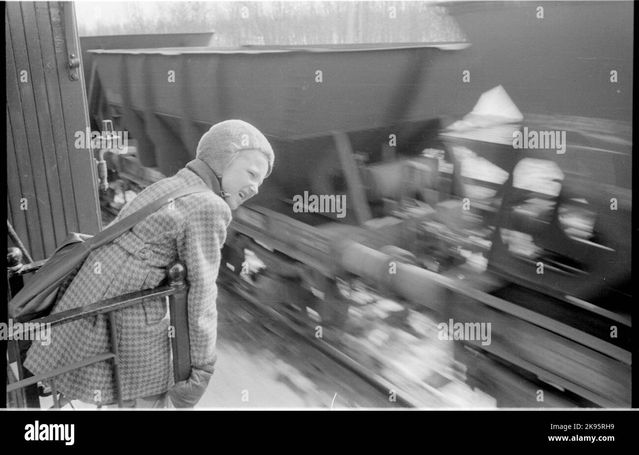 Un enfant regarde les trains qui passent. Banque D'Images