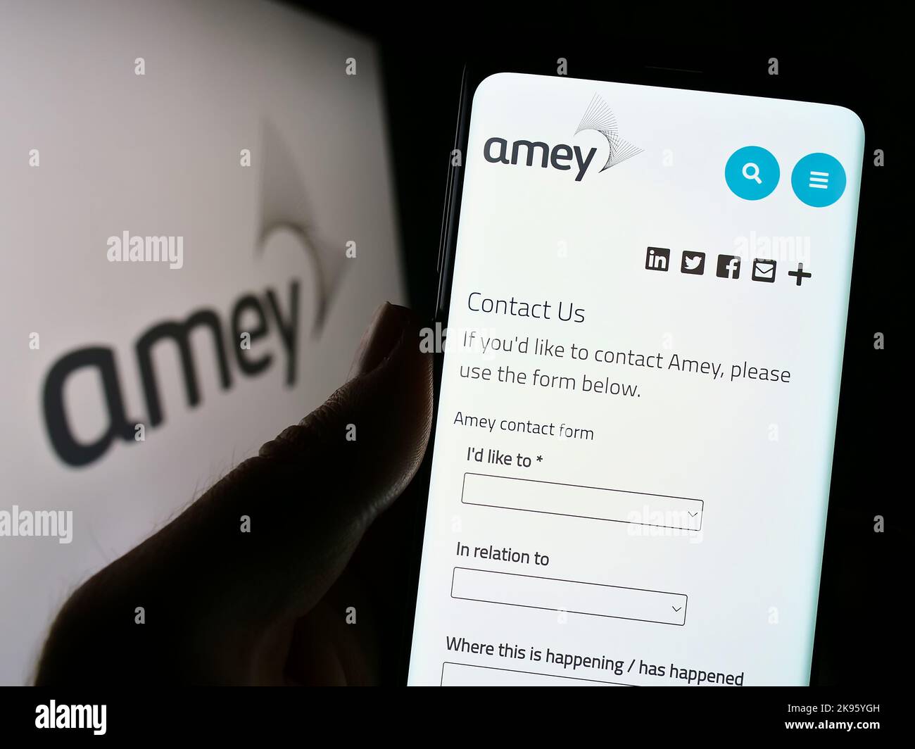 Personne tenant un téléphone portable avec la page Web de la société britannique d'infrastructure Amey plc à l'écran devant le logo. Concentrez-vous sur le centre de l'écran du téléphone. Banque D'Images