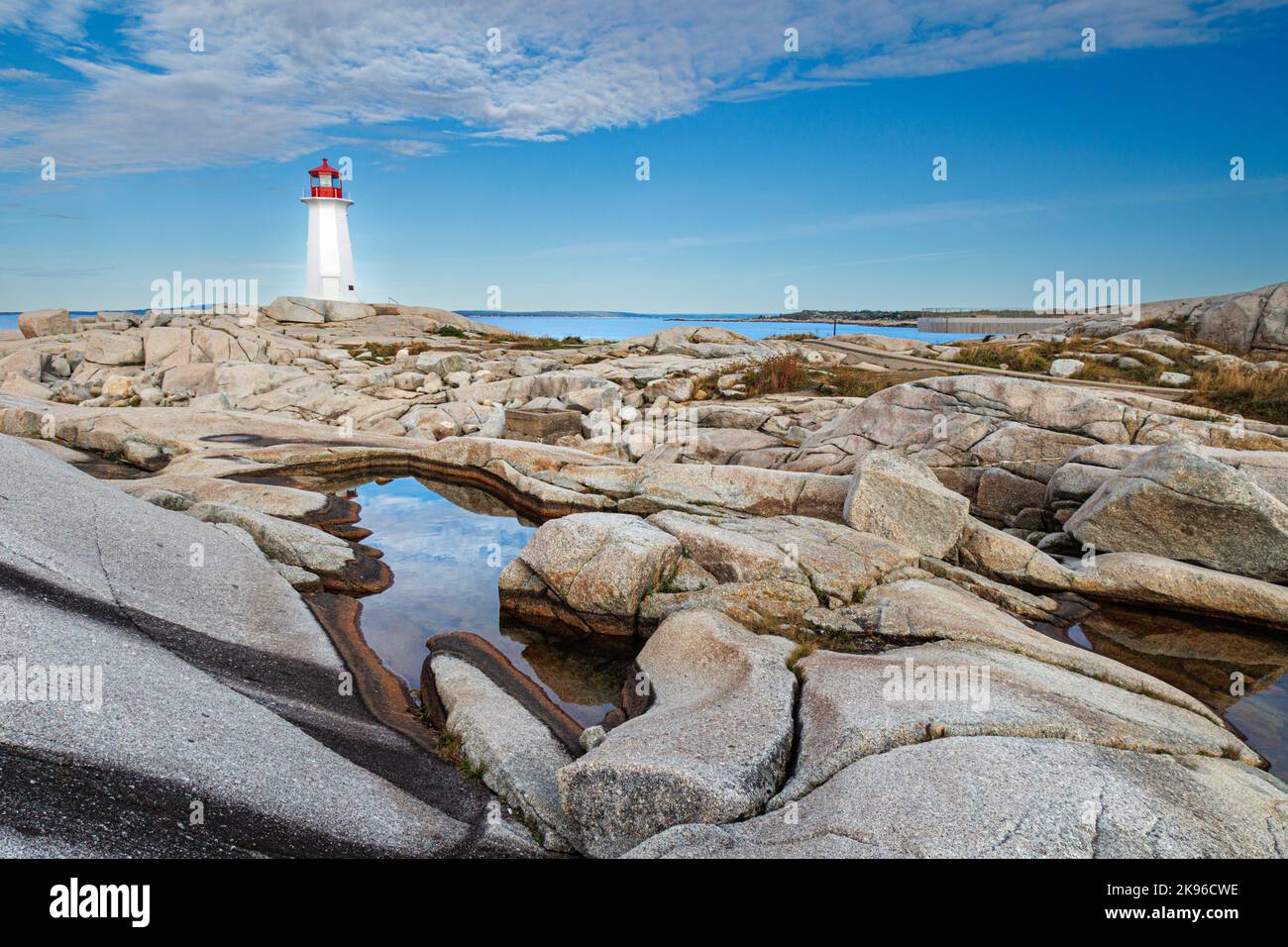 Peggys Cove Lighthouse vue sur les rochers prise un matin éclatant avec ciel nuageux Banque D'Images