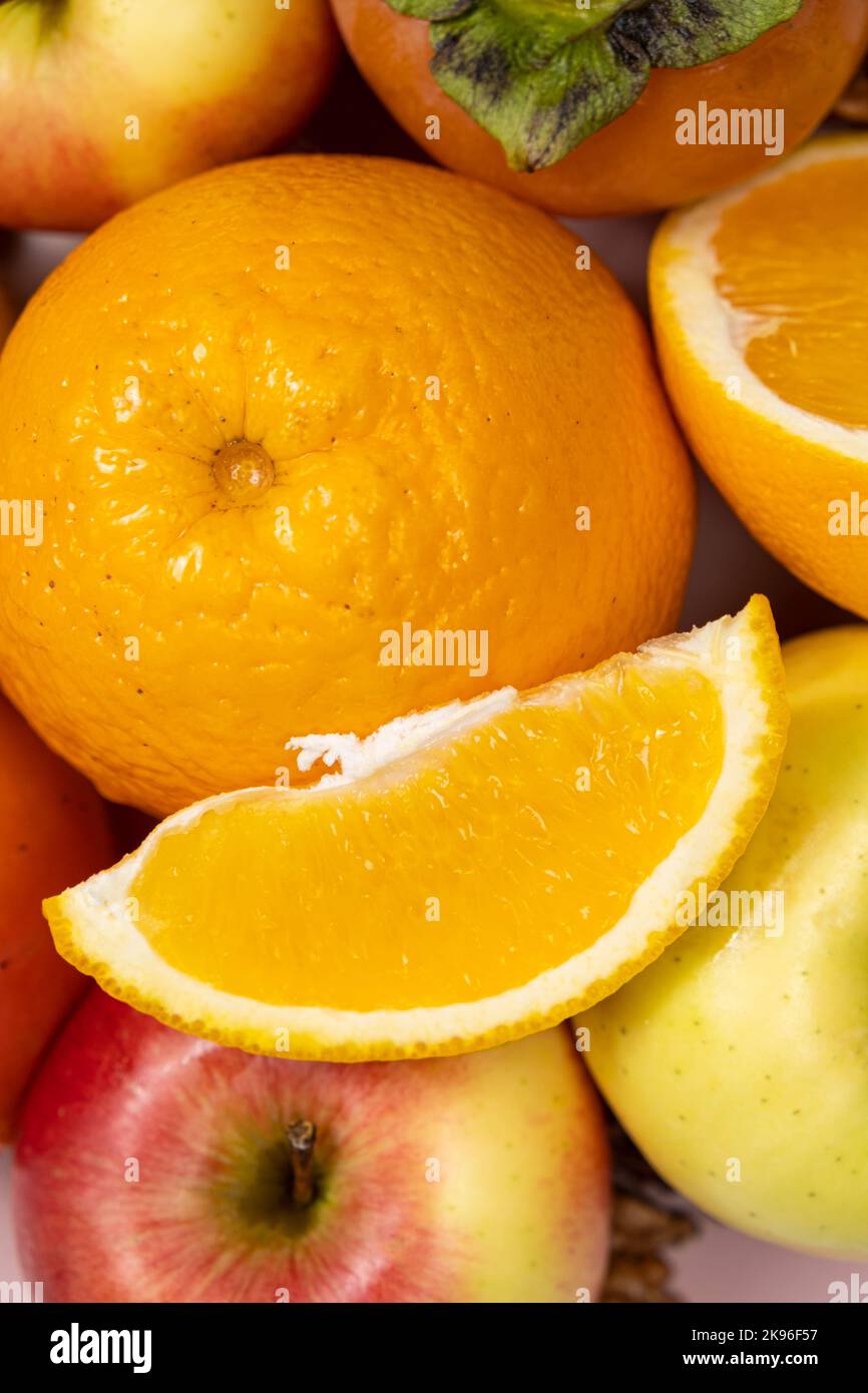 Les oranges, les tranches d'orange et les pommes en gros plan. Banque D'Images