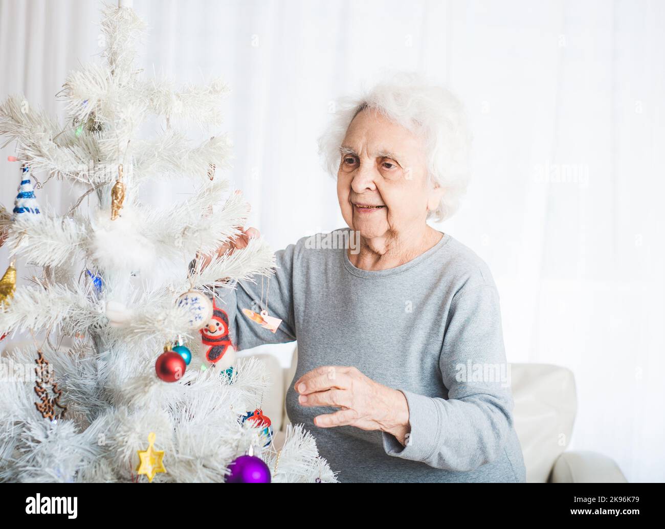 Femme senior décorant l'arbre de noël Banque D'Images
